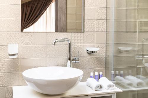 a bathroom with a bowl sink and a shower at Lavender Inn Guest House in Viešvėnai