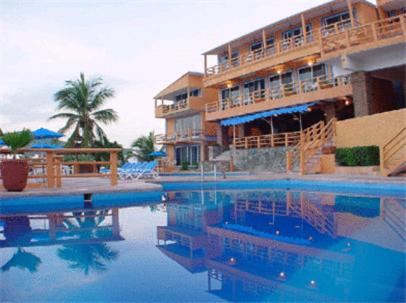 um hotel com piscina em frente a um edifício em Hotel Irma em Zihuatanejo