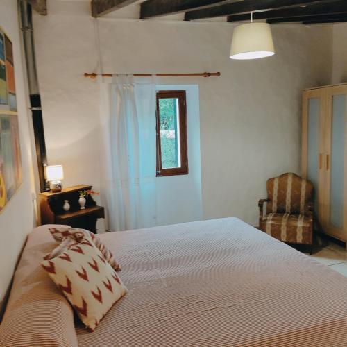 a bedroom with a large bed and a chair at Ca Na Menga in Sóller