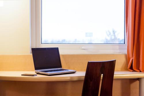 a laptop computer sitting on a table with a window at Ibis Juarez Consulado in Ciudad Juárez
