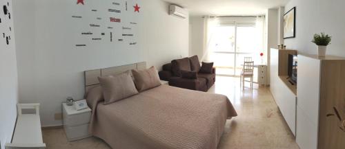 トレモリノスにあるNUEVO Roca Chica, Primera Línea Playa,Torremolinosのベッドルーム1室(ベッド1台付)、リビングルームが備わります。