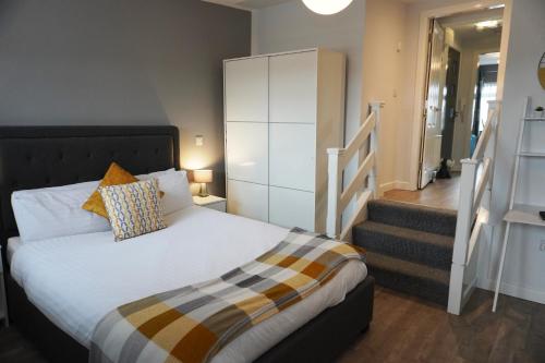 sypialnia z łóżkiem i schodami w obiekcie VIP Church Loft Apartment w mieście Portadown