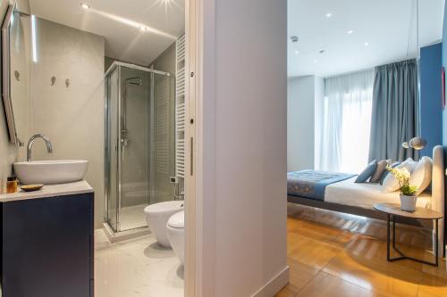a bathroom with a bed and a toilet and a sink at Missori Suites in Milan