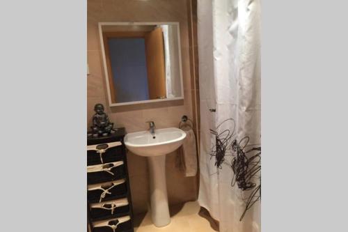 a bathroom with a sink and a shower with wine bottles at Vivienda Turística Mi Terraza in El Casar de Escalona