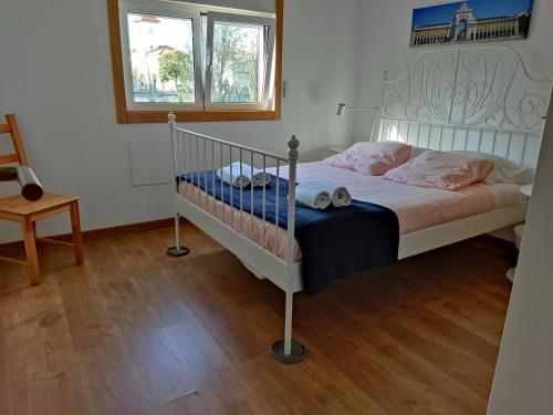 sypialnia z białym łóżkiem i różowymi poduszkami w obiekcie Best house airport lisbon w Lizbonie