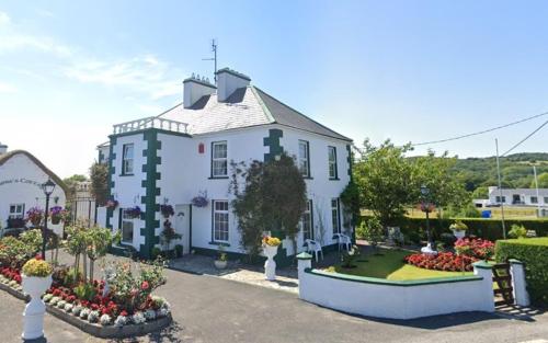 a large white house with flowers in front of it at Bruckless Rest - Fine Country Living in Milltown