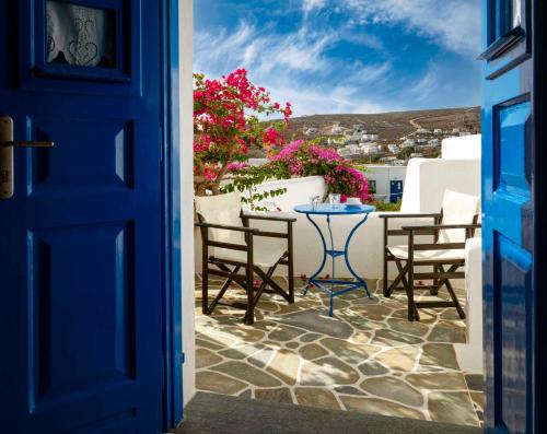 a blue door leading to a patio with a table and chairs at Meltemi in Chora Folegandros