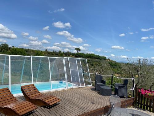 una terraza con 2 sillas y una piscina en Villetta Toscana - Montepulciano, en Montepulciano