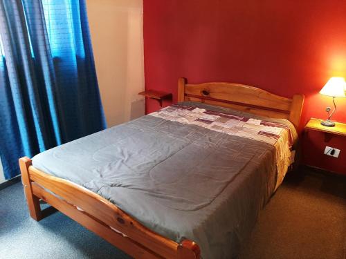 a wooden bed in a bedroom with a red wall at Duplex 7 Lunas in Villa Gesell