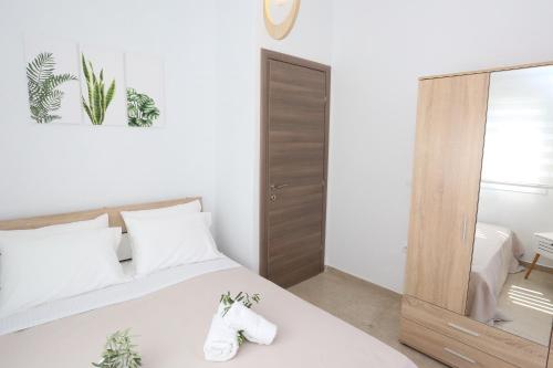 a bedroom with a white bed and a mirror at Mare Monte Luxury Apartments 1 in Nea Skioni