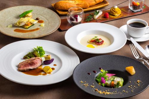 a table with plates of food on it at Hotel Neu Schloss Otaru in Otaru