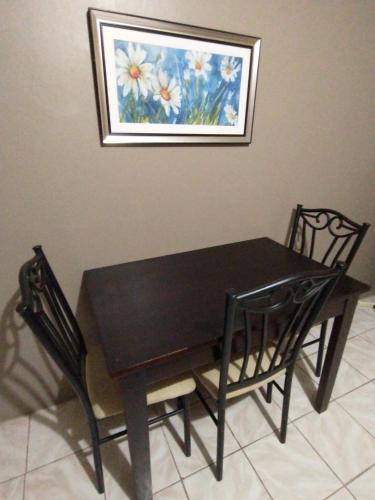 a black dining room table and chairs with a picture on the wall at Ultimate Freedom Bed and Breakfast in Santa Cruz