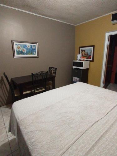 a bedroom with a bed and a table and a desk at Ultimate Freedom Bed and Breakfast in Santa Cruz