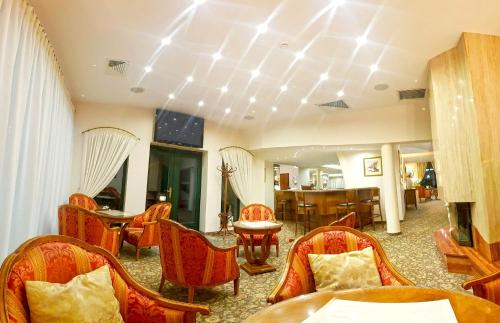 a room with chairs and a table and a fireplace at Hotel Amaryllis in Swarzędz