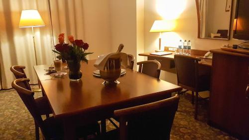 a hotel room with a table with flowers on it at Hotel Amaryllis in Swarzędz