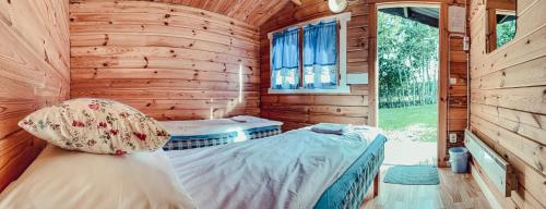 a bedroom with a bed in a log cabin at Pruuli Puhkeküla in Nurme
