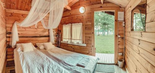 a bedroom with a bed in a wooden cabin at Pruuli Puhkeküla in Nurme