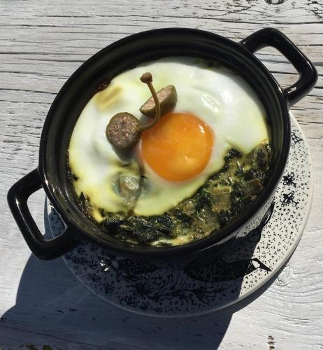 a frying pan with an egg and mushrooms on a table at 83 Bredynki in Biskupiec