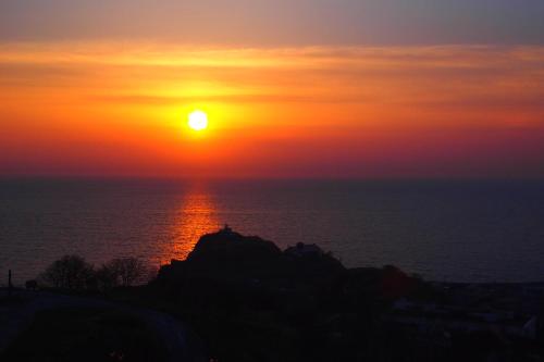 a sunset over the ocean with the sun setting at Hotel Neu Schloss Otaru in Otaru