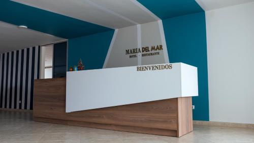 Hotel Maria del Mar في Planeta Rica: منضدة بيضاء في غرفة ذات جدار أزرق