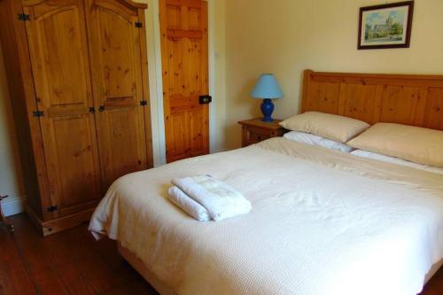 リムリックにあるSporting Lodge Shanagoldenのベッドルーム1室(ベッド1台に白いタオル2枚付)