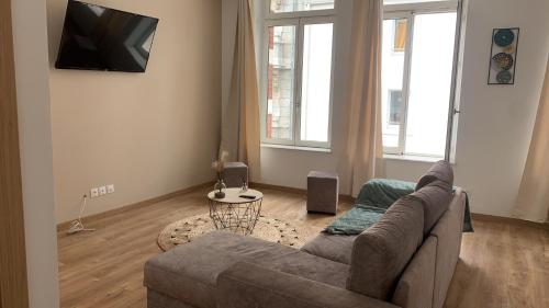 a living room with a couch and a flat screen tv at Appartement chaleureux in Boulogne-sur-Mer