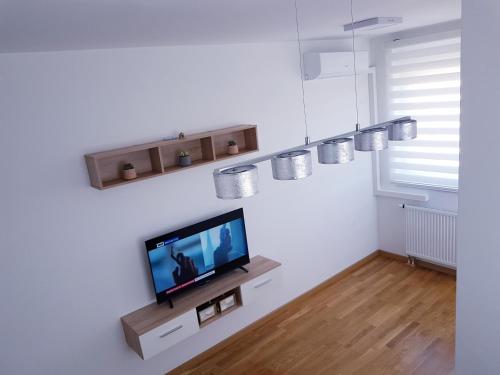 Apartman Istra, Doboj في دوبوي: غرفة معيشة مع تلفزيون على الحائط