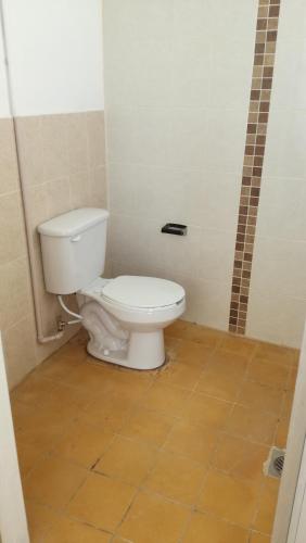 a bathroom with a toilet and a tiled floor at Casa Gaby in Morelia