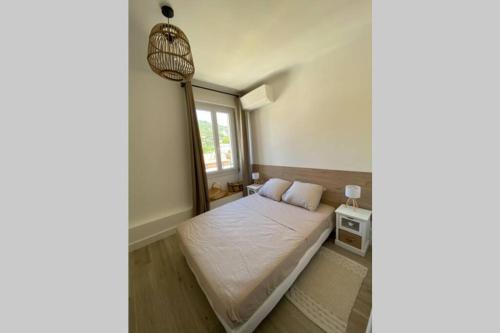 une petite chambre avec un lit et une fenêtre dans l'établissement Ajaccio magnifique T2 neuf 40m2 avec balcon au Trottel 4 couchages wifi Clim parking plage à pieds 100m, à Ajaccio