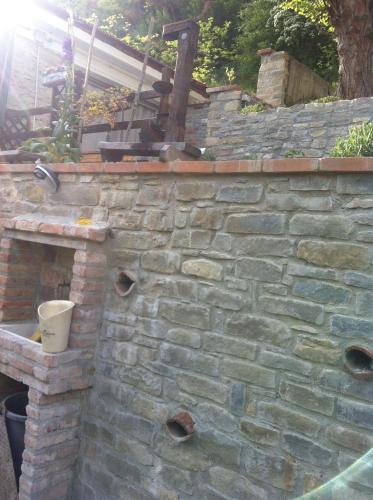 a stone wall with a brick oven in a yard at Villa Gioia in Acqui Terme