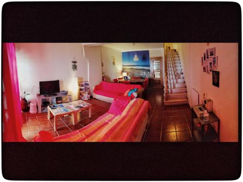 a living room with a red couch and a table at Supertubos Beach Hostel in Peniche
