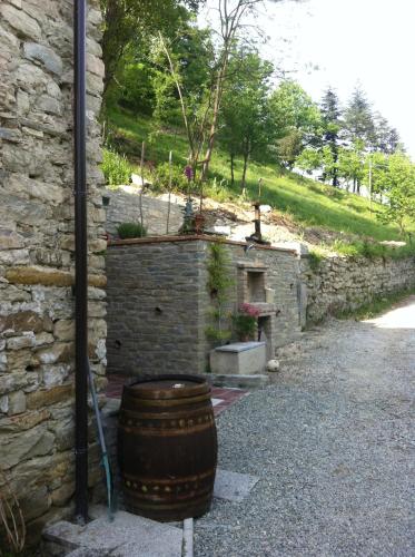 a barrel sitting next to a stone building with a tree in it at Villa Gioia in Acqui Terme