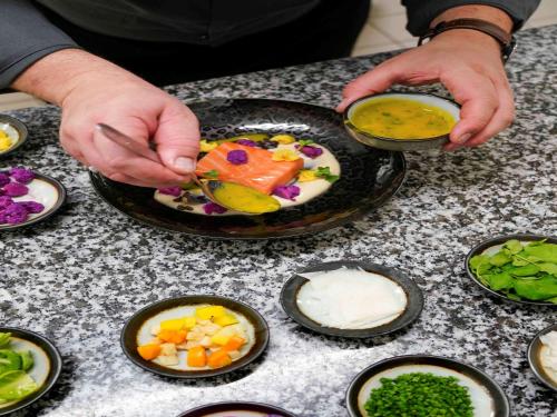 a person is preparing a plate of food on a table at La Citadelle Hotel Metz - MGallery Collection in Metz