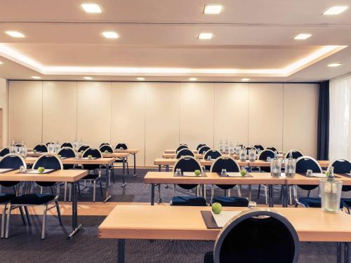 an empty classroom with rows of tables and chairs at Mercure Hotel Bielefeld Johannisberg in Bielefeld