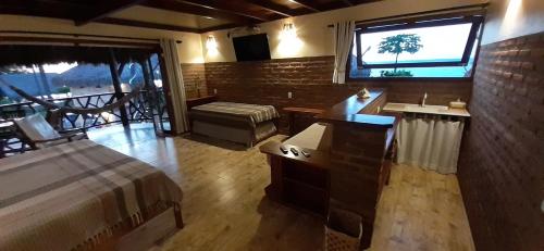 a bedroom with a bed and a large window at Pousada Lacula in Praia de Moitas