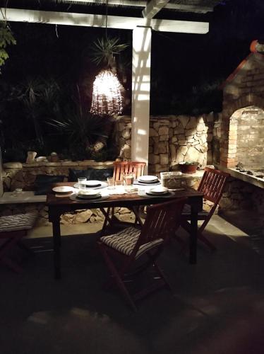 a wooden table with two chairs and a chandelier at Getaway house Gundula in Podstražje