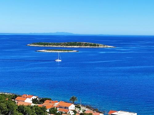 a small island with a sail boat in the water at Getaway house Gundula in Podstražje