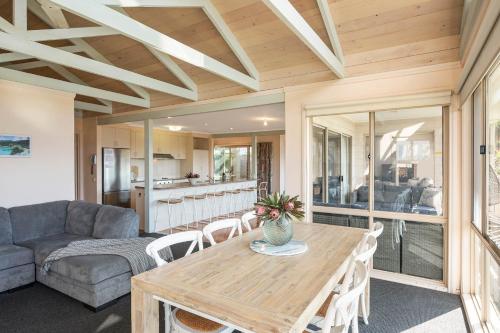 a living room with a table and a couch at Pelican Lake Holiday House in Merimbula