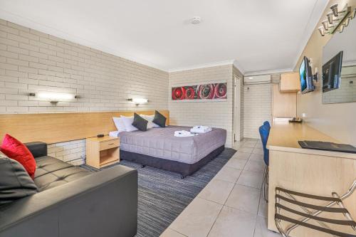 a bedroom with a bed and a couch in a room at Stagecoach Inn Motel in Tamworth