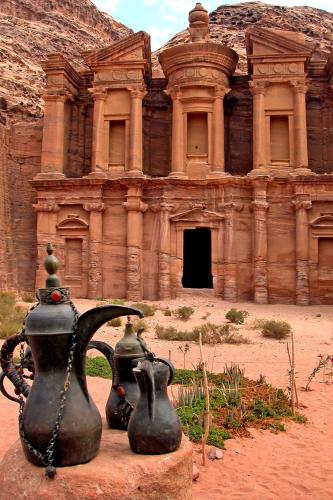 an ancient building with two vases in front of it at Petra Heart Hotel in Wadi Musa