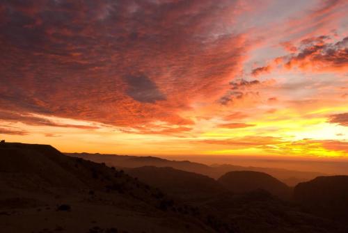 a sunset in the desert with mountains in the background at Petra Heart Hotel in Wadi Musa