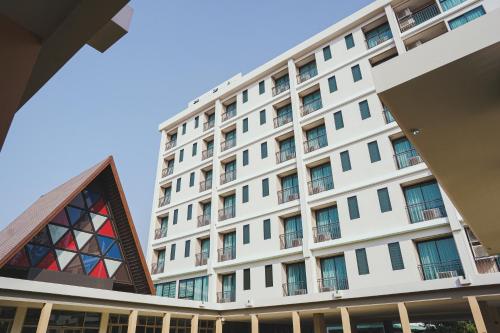 a large white building with a triangle at The Cotton Tree Hometel in Khon Kaen