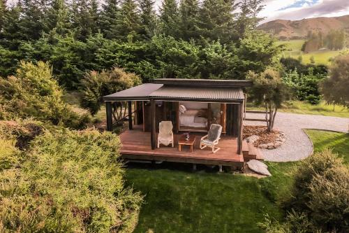 a gazebo with two chairs in a garden at The Kanuka Cabin in Wanaka