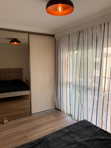 une chambre avec un lit et une grande fenêtre dans l'établissement Superbe 2 pièces à 50 m de la Promenade des Anglais, à Nice