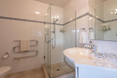 bagno con doccia in vetro e lavandino di Parkhill Accommodation a Whangarei