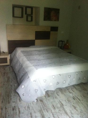 a bedroom with a large bed with white sheets at Villa Gioia in Acqui Terme