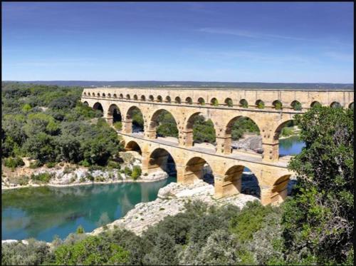 eine Brücke mit vielen Bögen über einen Fluss in der Unterkunft Studio Uzès Pont du Gard in Argilliers