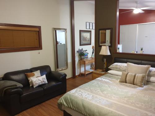 a large bedroom with a bed and a couch at Equestrian Farm Stay in One Tree Hill