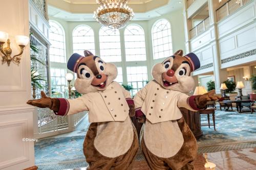 two people dressed up in costumes in a hotel lobby at Hong Kong Disneyland Hotel in Hong Kong