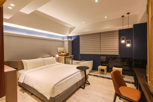 a bedroom with a bed and a desk and a chair at 墾丁耳東華苑ErDong Manor in Kenting
